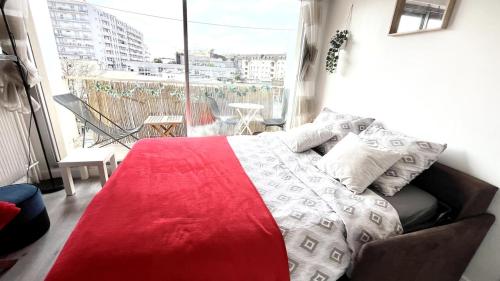 - une chambre dotée d'un lit avec une couverture rouge et blanche dans l'établissement Sunny Studio with Balcony - buttes Chaumont park, à Paris