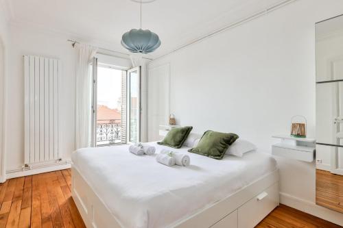 une chambre blanche avec un grand lit blanc et une fenêtre dans l'établissement GuestReady - Family Retreat near Paris, à Saint-Denis