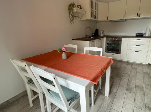 a kitchen with a white table with a red table cloth at Hišica na morju in Ankaran