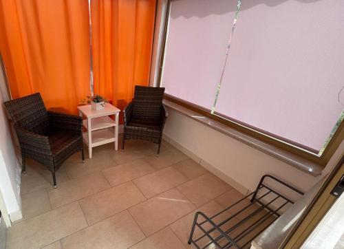 a classroom with two chairs and a white screen at Hišica na morju in Ankaran