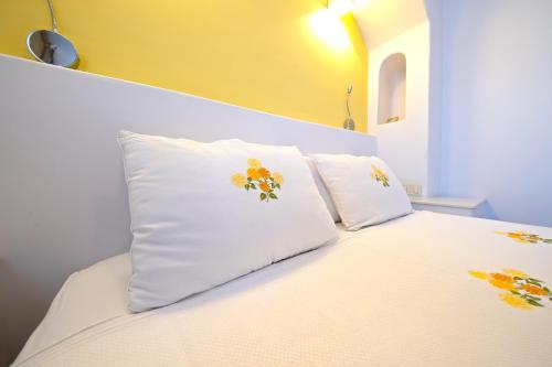 a white bed with two pillows on top of it at Sigacik Gardenya Buti̇k Otel in Siğacık