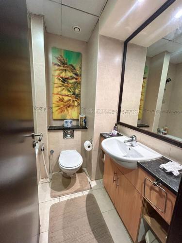 a bathroom with a sink and a toilet and a mirror at Click Stay - JLT - Studio & Balcony Lakes view Entire Apartment -JN in Dubai