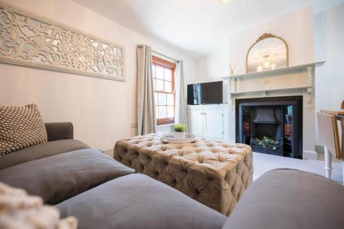 a living room with a couch and a fireplace at 3a Childs Yard, Southwold in Southwold