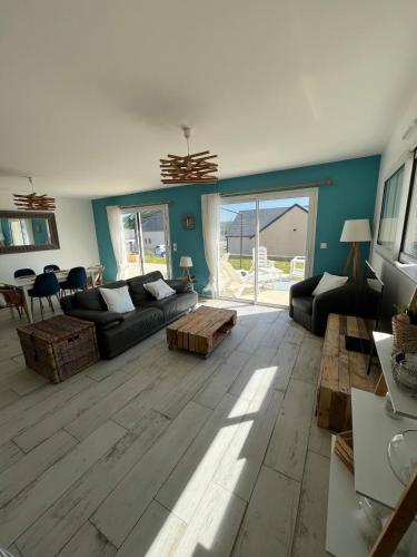 a living room with a couch and a table at La P'tite Huguette in Port-en-Bessin-Huppain