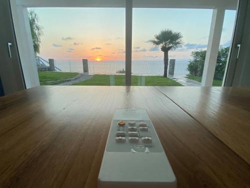 a remote control sitting on a wooden floor in front of a window at Villa Taurus Costa dei Monaci Parghelia Tropea in Parghelia
