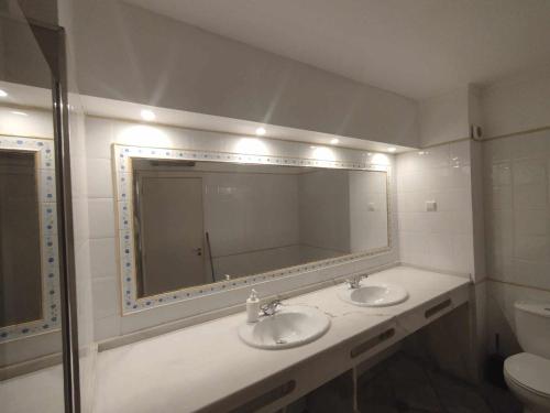 a bathroom with two sinks and a large mirror at douceur d'algarve in Albufeira