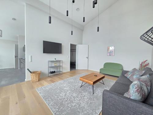 a living room with a couch and a table at Ferienwohnung Penthouse Wasserperle in Norden