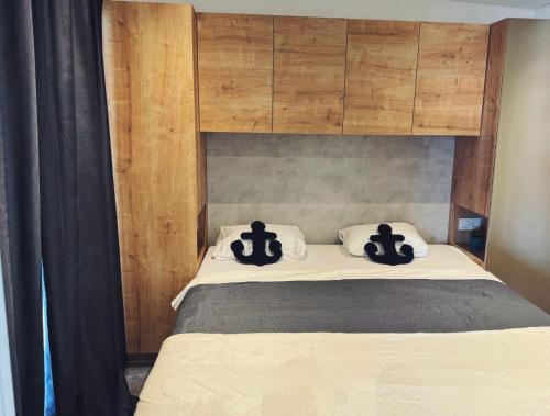 a bedroom with a bed with two black pillows at Sea view BluEscape by Vellaris, Luxury Mobile Home in Mali Lošinj