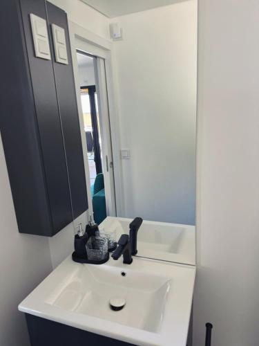 a bathroom with a white sink and a mirror at Sea view BluEscape by Vellaris, Luxury Mobile Home in Mali Lošinj