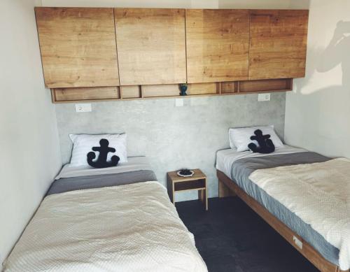 two twin beds in a room with a wooden ceiling at Sea view BluEscape by Vellaris, Luxury Mobile Home in Mali Lošinj