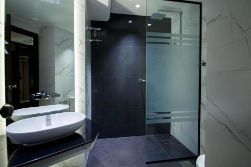 a bathroom with a sink and a glass shower at Hotel Hillview Islamabad in Islamabad