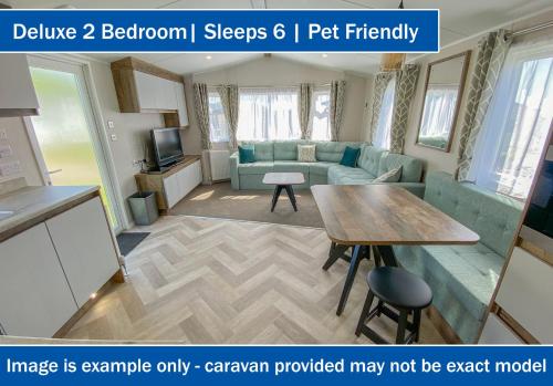a living room with a couch and a table at Crows Nest Caravan Park in Filey