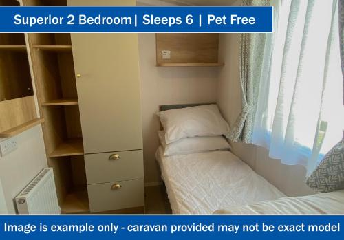 a small bedroom with a bed and a cabinet at Crows Nest Caravan Park in Filey