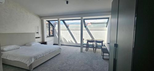 a bedroom with a bed and a table and a balcony at Old Avenue Hotel in Gyumri