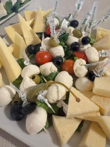 a plate of cheese and grapes and other foods at Hotel Porto Azzurro in Sirmione