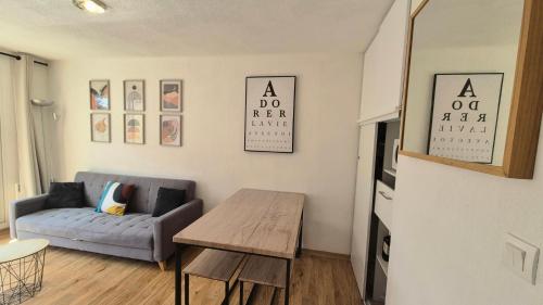 un salon avec un canapé et une table dans l'établissement Chez Florie - Résidence Les Cimes à la Foux d'Allos 6 couchages piscine sauna et hammam, à La Foux d'Allos