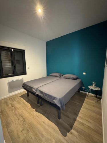 une chambre avec un lit avec un mur bleu dans l'établissement Casaso, à Mondragon