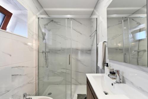 a bathroom with a shower and a toilet and a sink at Casa do Alfaiate - Piscina & Barbecue - Gerês in Rego