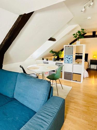 un salon avec un canapé bleu et une table dans l'établissement Dalikyda - La Perle de Montivilliers, à Montivilliers