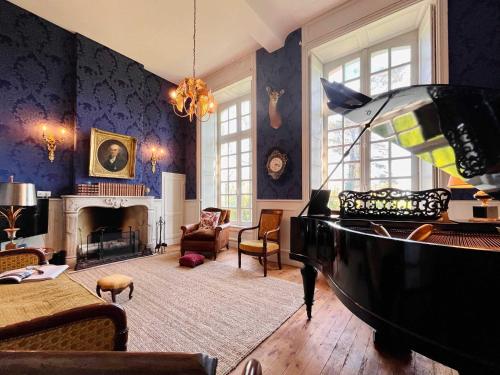 une chambre avec un piano et un salon aux murs bleus dans l'établissement Chateau de Gourmont Dream Stay in a Norman Castle, à Saint-Germain-de-Varreville