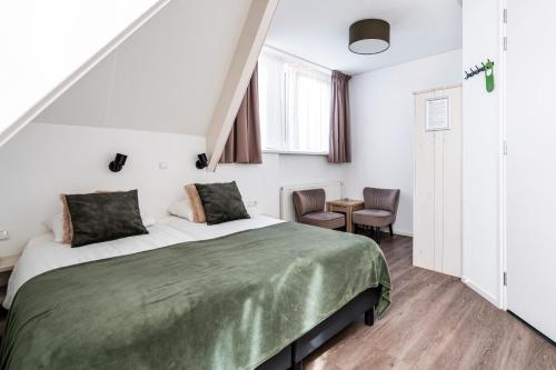 a bedroom with a bed and a table and chairs at Duinhotel Haga in Zoutelande