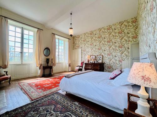 - une chambre avec un grand lit et du papier peint floral dans l'établissement Chateau de Gourmont Dream Stay in a Norman Castle, à Saint-Germain-de-Varreville