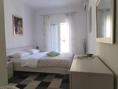 a white bedroom with a bed and a window at Summer Breeze Cavtat in Cavtat