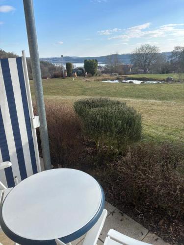a white table and chairs on a porch with a field at Kleine FeWo mit Seeblick in Spalt