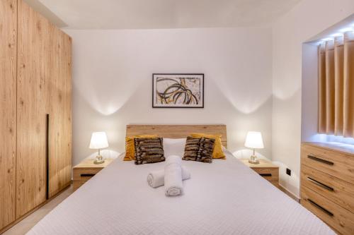 a bedroom with a large bed with two lamps at Amazing apartment with pool in Malta in Is-Swieqi