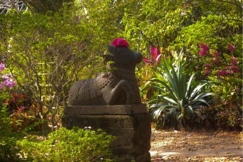 a statue of a woman sitting on a rock in a garden at Gaia's Garden Guest House in Auroville