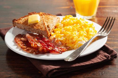 a plate of breakfast food with eggs bacon and toast at Hotel Sole - Limone in Limone sul Garda