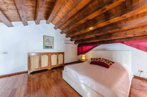a bedroom with a bed and a wooden ceiling at Novalesi Red House in Noale