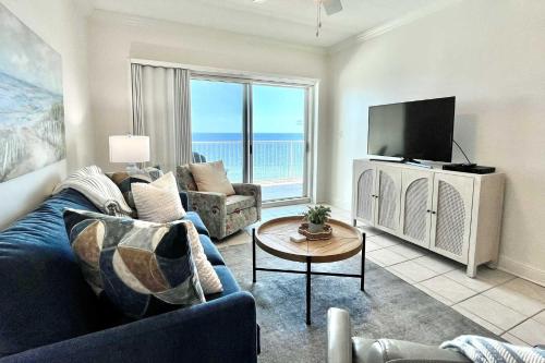 a living room with a blue couch and a tv at Crystal Shores1006 condo in Gulf Shores