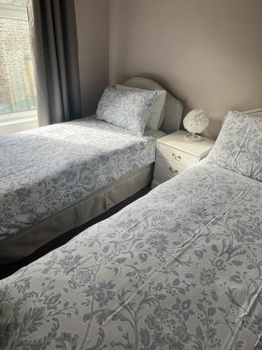 a bedroom with two beds and a window at Katys Cottage, Barnoldswick in Barnoldswick