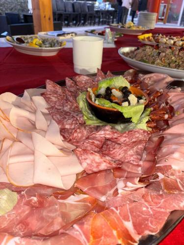 a table with a plate of meats and vegetables at Hotel Sporting in Casarsa della Delizia