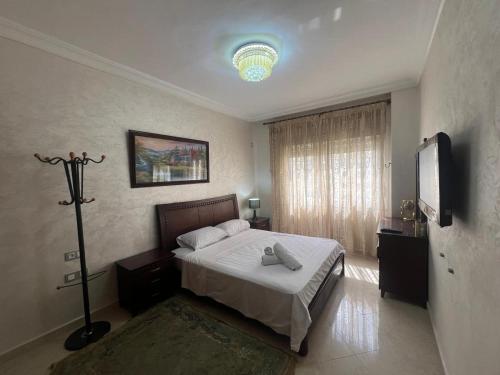 Un dormitorio con una cama y un televisor. en Tout à pied - vue mer et plage, en Tánger