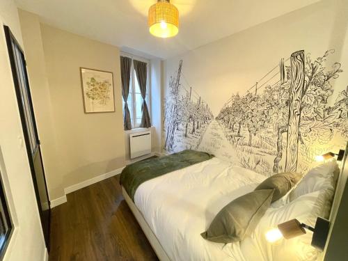 a bedroom with a bed with a drawing on the wall at Le Millésime - Hypercentre in Mâcon