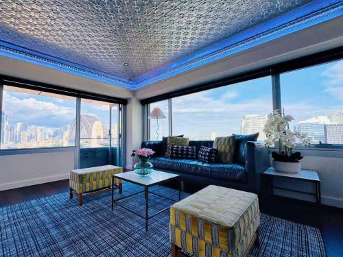 a living room with a couch and large windows at Sydney Harbour and CBD View Penthouse with Free Parking in Sydney