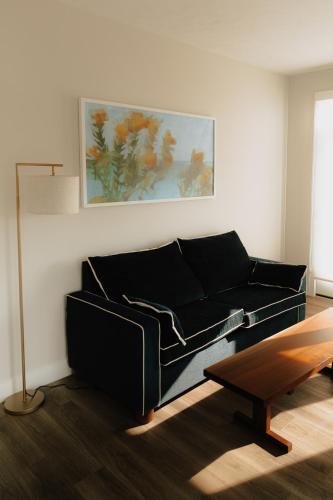 a living room with a black couch and a table at The Dexter by Kasa in Elk Rapids