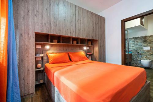 ein Schlafzimmer mit einem orangenen Bett und einem Spiegel in der Unterkunft La piuma apartment in Quartu SantʼElena