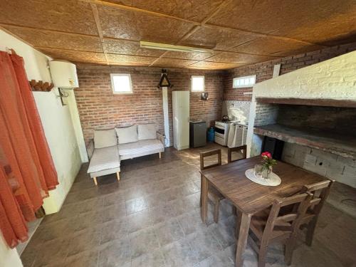 a living room with a table and a fireplace at Apartamento al fondo de la casa in Fray Bentos