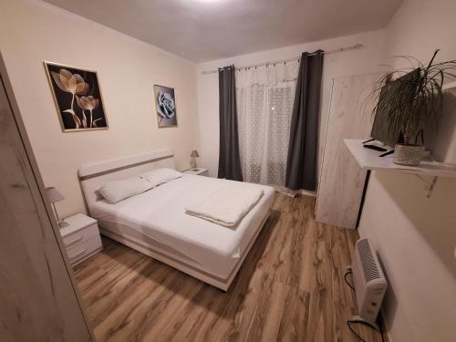 a bedroom with a white bed and a wooden floor at Vavic 2 in Topla