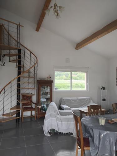 une chambre avec un lit et un escalier en colimaçon dans l'établissement Belle maison Vallée du Lot., à Prayssac