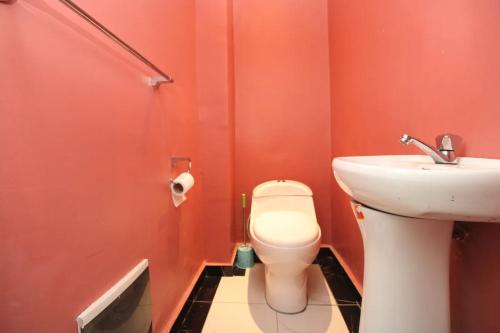 a bathroom with a toilet and a sink at Afriqpnb RAP Studio 102 avec Piscine in Douala