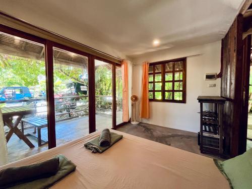a bedroom with a bed and a large window at Hermit Bungalow #1 in Catangnan Gen Luna w STARLINK WIFI in General Luna