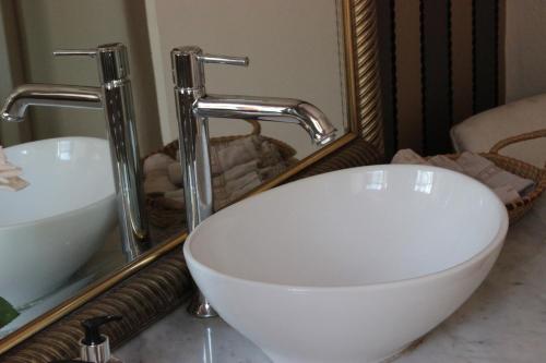 a bathroom with a white sink and a mirror at Vredenburg Manor House in Somerset West
