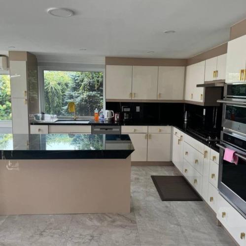 a large kitchen with white cabinets and a large window at Beautiful Breezy Lake House! in Pickering