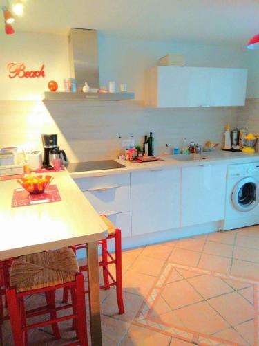 une cuisine avec une table et une machine à laver dans l'établissement GRANDE PLAGE A 50 Métres, à Valras-Plage