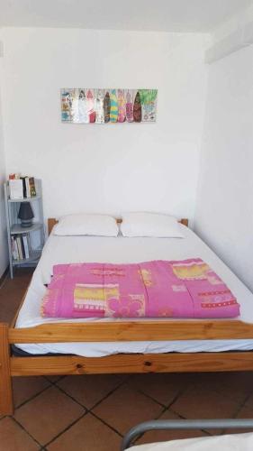 - un lit avec une couverture rose dans l'établissement GRANDE PLAGE A 50 Métres, à Valras-Plage