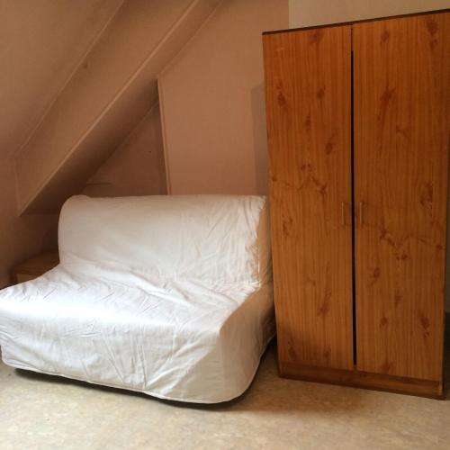 une chambre avec un lit et une armoire en bois dans l'établissement Studio plein centre ville Dijon, à Dijon